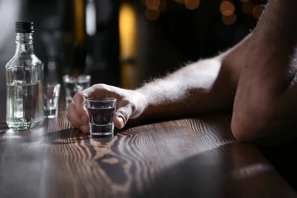 Чоловік зі склянкою напою в барі, крупним планом. Проблема алкоголізму — стокове фото