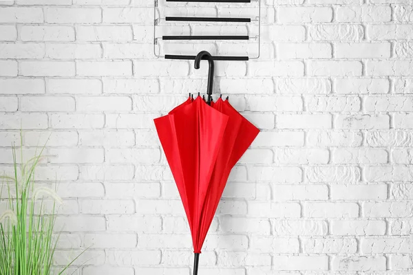 Parapluie rouge élégant suspendu au mur à l'intérieur — Photo