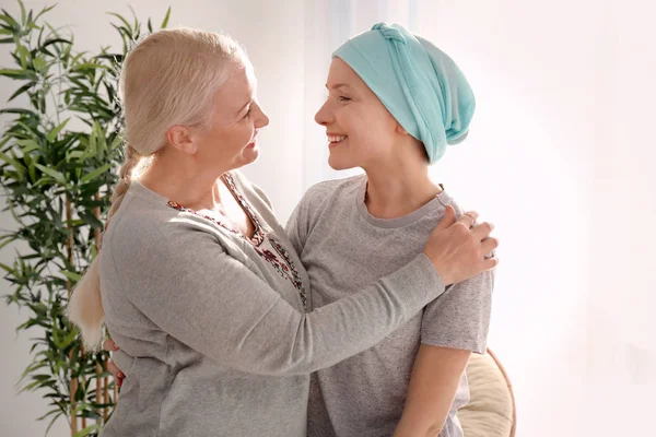 Mujer madura visitando a su hija con cáncer en interiores — Foto de Stock