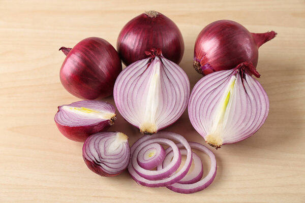 Ripe red onions on light background