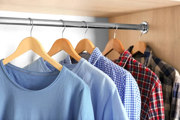 Hangers with different clothes in wardrobe closet — Stock Photo, Image