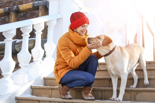 Mulher andando cão bonito ao ar livre no dia de inverno. Amizade entre animal de estimação e proprietário — Fotografia de Stock