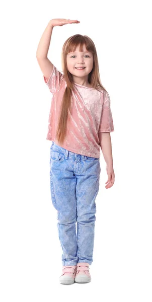 Schattig klein meisje meten van haar hoogte op witte achtergrond — Stockfoto