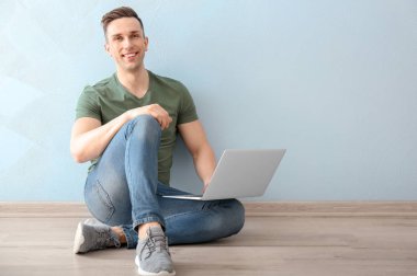 Genç adam dizüstü bilgisayar kullanıyor  