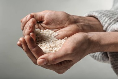 Zavallı kadın elinde, closeup pirinç tutan