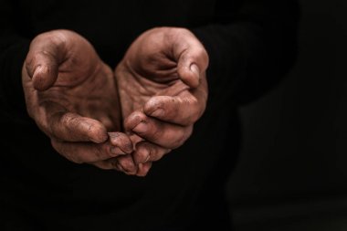 Zavallı adam koyu arka plan üzerinde para için yalvarıyor