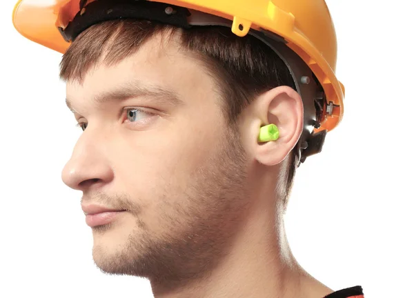 Operaio maschio con tappi per le orecchie su sfondo bianco. Apparecchi per la protezione dell'udito — Foto Stock