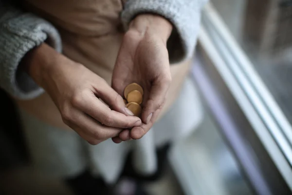 Pauvre femme tenant des pièces de monnaie, gros plan — Photo