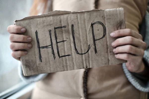 Бідна жінка тримає шматок картону зі словом HELP, крупним планом — стокове фото