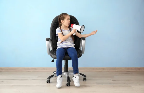 Emocjonalne dziewczynka z megafon siedzący na krześle w pustym pokoju — Zdjęcie stockowe