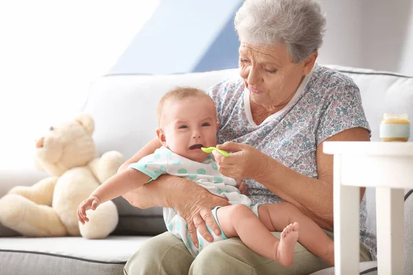 Senior vrouw voeden haar weinig kleinkind thuis — Stockfoto