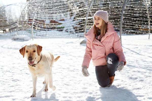 Woman walking cute dog outdoors on winter day. Friendship between pet and owner — Stock Photo, Image