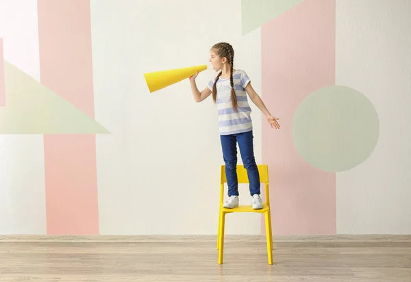 Menina de pé na cadeira e gritando em papel megafone dentro de casa — Fotografia de Stock