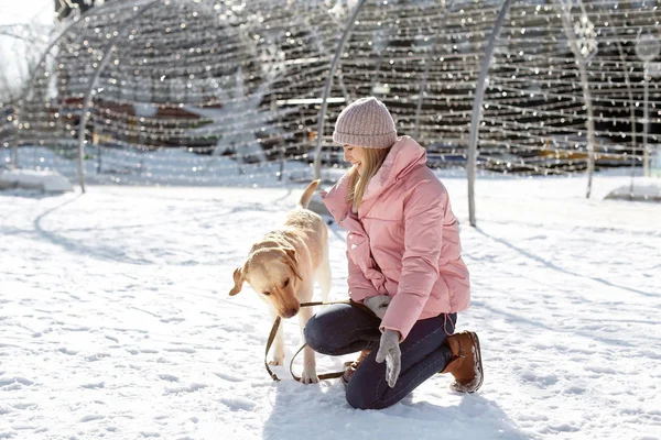 Woman walking cute dog outdoors on winter day. Friendship between pet and owner — Stock Photo, Image