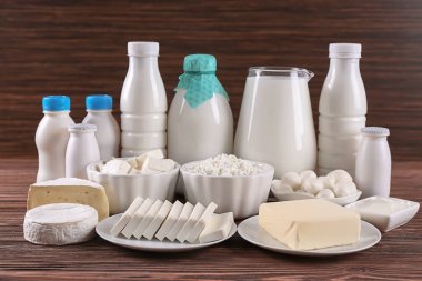 Different dairy products on wooden table clipart