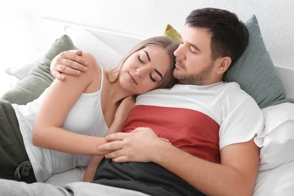 Morgen eines jungen schönen Paares, das zu Hause auf dem Bett liegt — Stockfoto