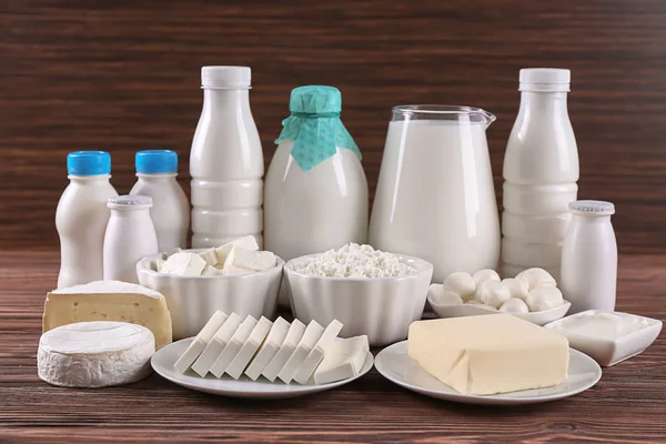 Produtos lácteos diferentes na mesa de madeira — Fotografia de Stock