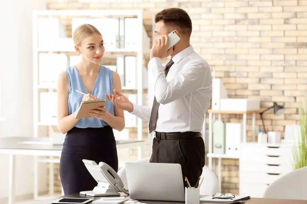 Recepcionista masculino con aprendiz en el lugar de trabajo — Foto de Stock