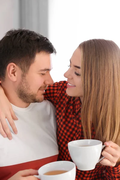 Bonito jovem casal lindo beber chá em casa — Fotografia de Stock