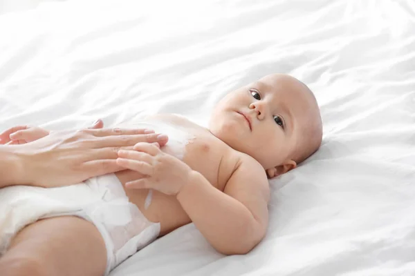 Vrouw lichaam crème toe te passen op haar baby binnenshuis — Stockfoto
