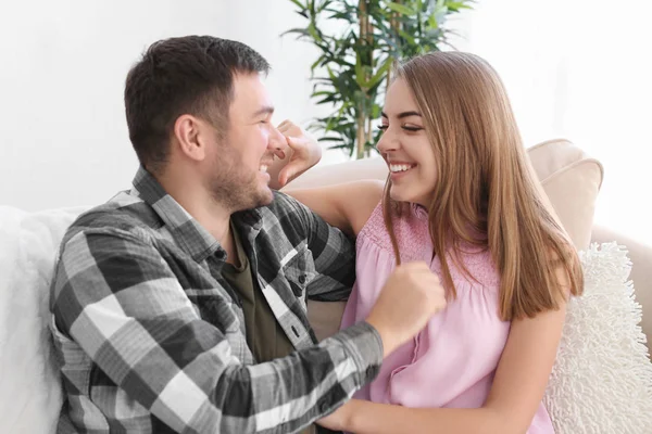 Söt unga vackra paret sitter på soffan hemma — Stockfoto