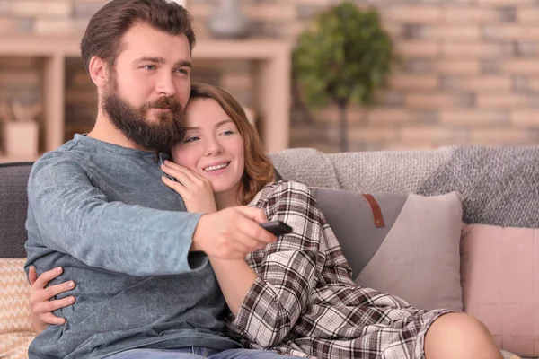 Boldog pár tévénézés közben ül a kanapén, otthon — Stock Fotó