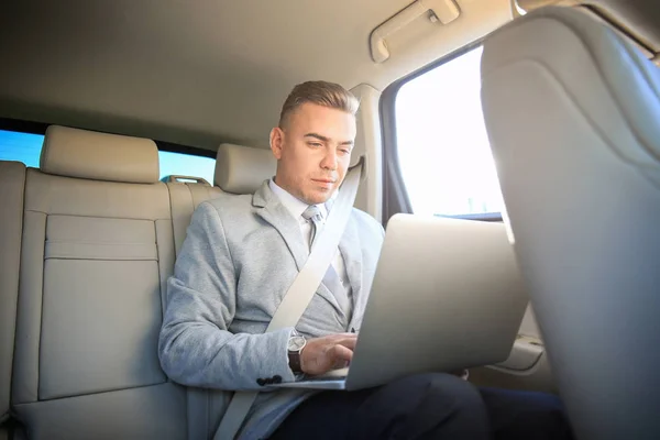 Homem em desgaste formal com laptop no carro — Fotografia de Stock