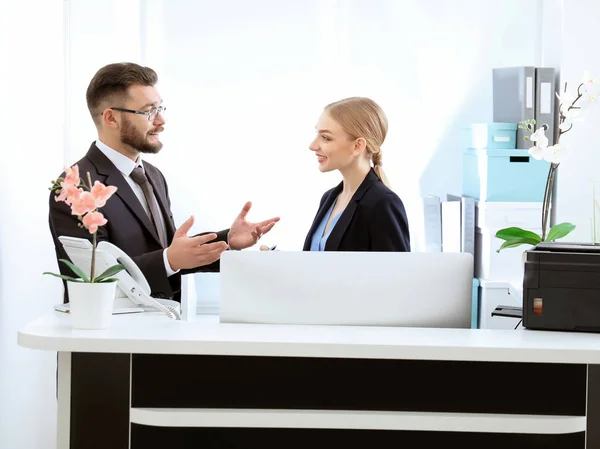 Recepcionista masculino com estagiário no local de trabalho — Fotografia de Stock