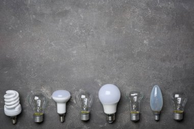 Gri arka plan üzerinde LED, akkor ve flüoresan lambalar