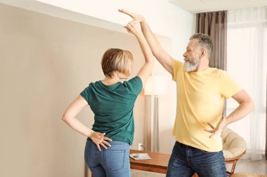 Mutlu olgun çift evde dans ediyor.