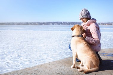 Sevimli köpek kış gününde Nehri yakınında olan kadın. Evde beslenen hayvan ve sahibi arasındaki dostluk