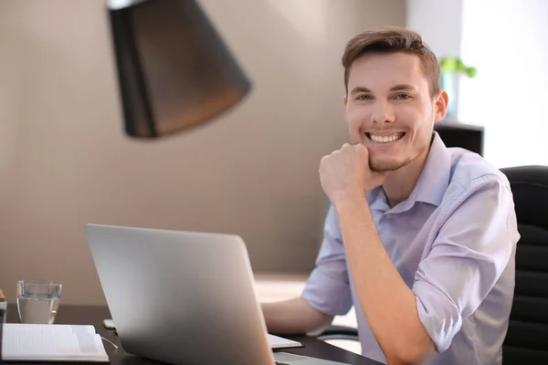 Jeune homme travaillant avec ordinateur portable à l'intérieur — Photo