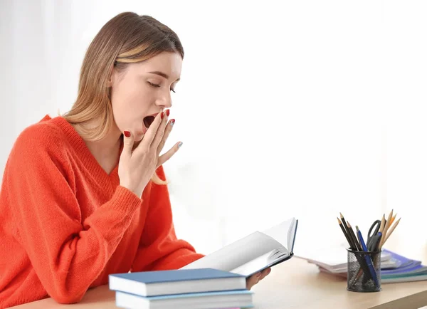 Moe mooie student studeert aan tafel binnenshuis — Stockfoto