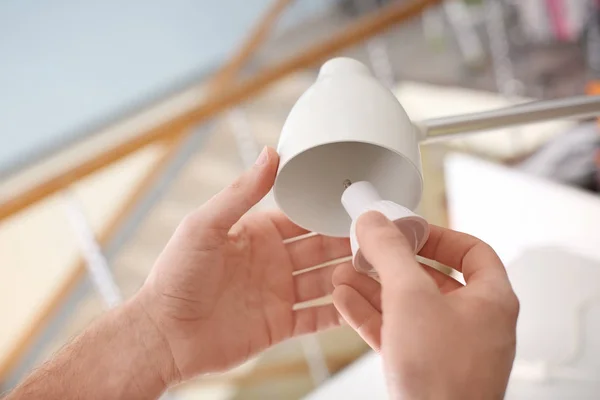 Man changing light bulb in lamp at home — Stock Photo, Image