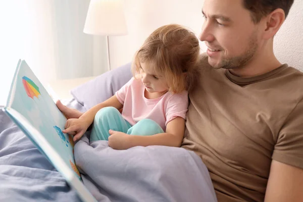 父亲与小女儿阅读睡前故事在家里 — 图库照片