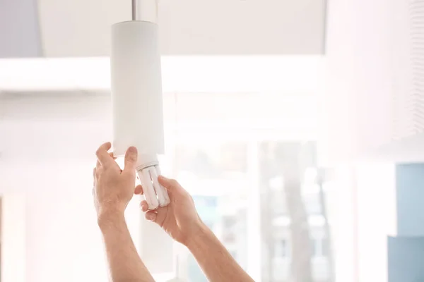 Man changing light bulb in lamp at home — Stock Photo, Image