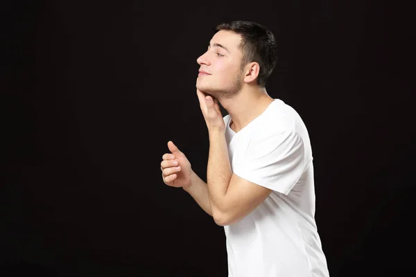 Junger Mann Bewirbt Sich Nach Der Rasierlotion Auf Dunklem Hintergrund — Stockfoto