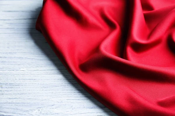 Têxtil vermelho sobre fundo de madeira. Textura de tecido — Fotografia de Stock