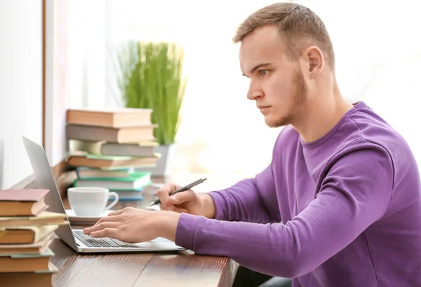 Ung man arbetar med laptop i ljusrummet — Stockfoto