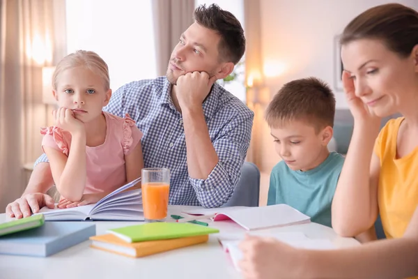 両親の家で宿題をするいると小さな子供たち — ストック写真