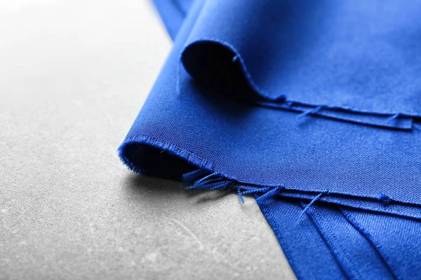 Kék textil szürke háttéren. Szövet szerkezete — Stock Fotó