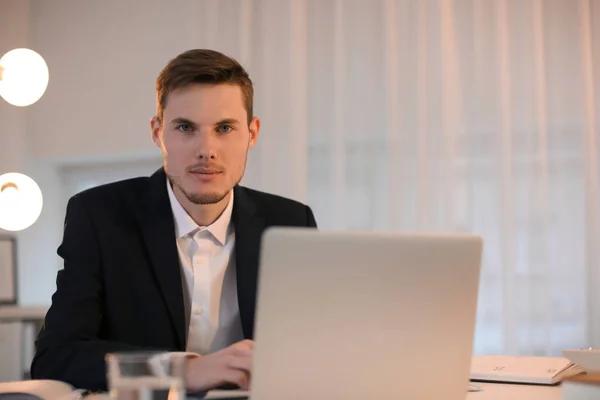 Jeune homme d'affaires travaillant avec un ordinateur portable à l'intérieur — Photo