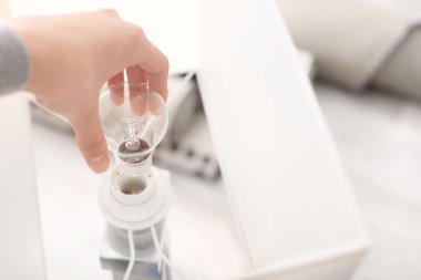 Kadın evinde ampulü değiştiriyor.