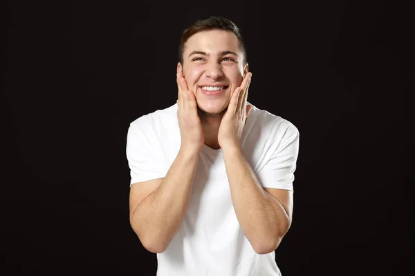 Junger Mann Bewirbt Sich Nach Der Rasierlotion Auf Dunklem Hintergrund — Stockfoto