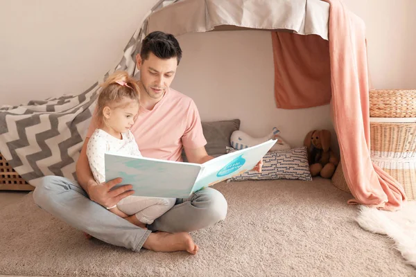 父亲和女儿在儿童室地板上看书 — 图库照片