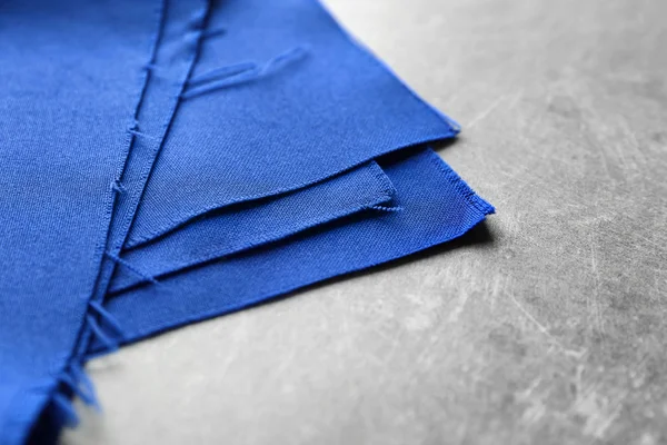 Blaues Textil auf grauem Hintergrund. Gewebestruktur — Stockfoto