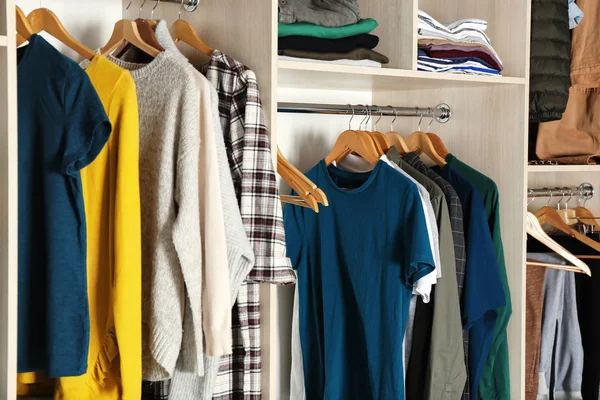 Perchas con ropa diferente en armario — Foto de Stock