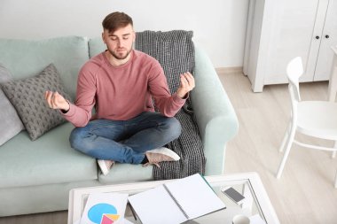 Genç adam meditasyon duruş evde rahatlatıcı
