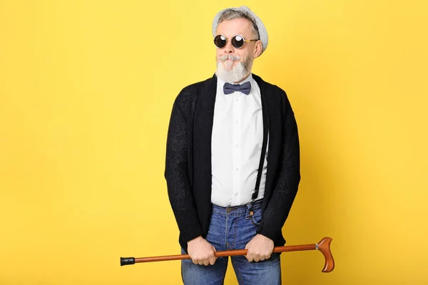 Щасливий старший чоловік в хіпстерському вбранні на кольоровому фоні — стокове фото