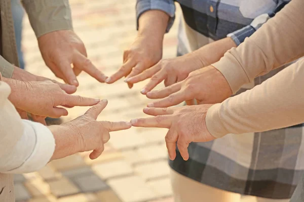 Vezető gondozó otthon kezek összerakva, mint szimbólum az egység kint az emberek — Stock Fotó